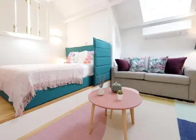 a bedroom with a bed and a couch and a table at Ribeira apartment 6M- vista fabulosa in Porto