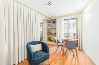 a living room with a blue chair and a table at Locally Yours Flores Apartments in Porto