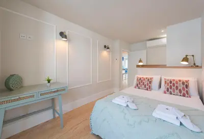 a white bedroom with a bed and a desk at Porta do sol Luxury Apartment in Porto