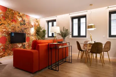 a living room with a red couch and a table at Byobu Apartment, by Bolhão Residences in Porto