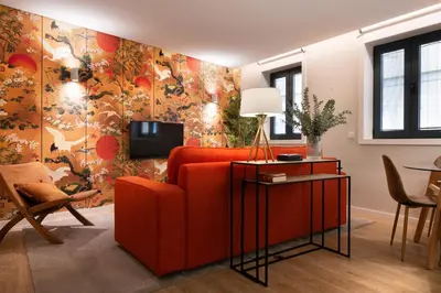 a living room with a red couch and a tv at Byobu Apartment, by Bolhão Residences in Porto