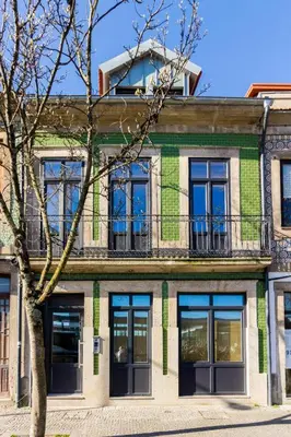 a green building with a balcony on top of it at Oporto Modern Apartments - Campanha Train Station in Porto
