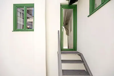 a ladder leading up to a door with a mirror at D. João IV Apartments by LovelyStay in Porto