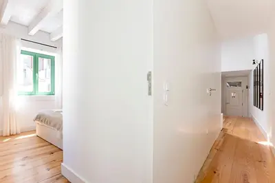 a room with white walls and wooden floors at D. João IV Apartments by LovelyStay in Porto