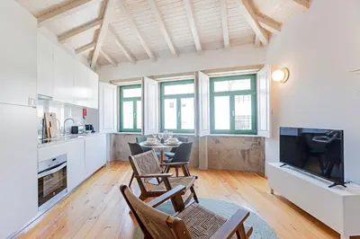 a kitchen and living room with a table and chairs at D. João IV Apartments by LovelyStay in Porto