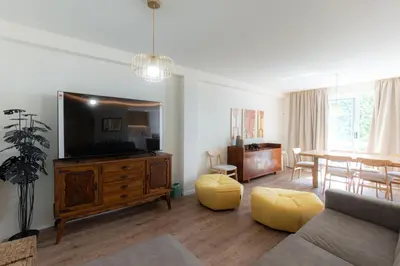 a living room with a flat screen tv and a table at Alegria Porto by We Do Living in Porto