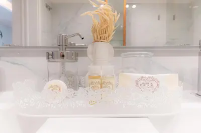 a bathroom counter with a sink with a vase and cosmetics at Alegria Porto by We Do Living in Porto