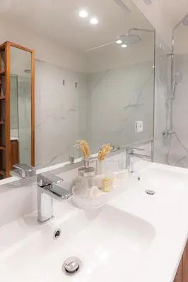 a bathroom with a white sink and a mirror at Alegria Porto by We Do Living in Porto