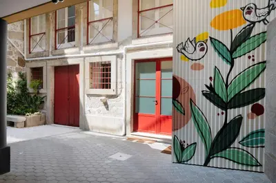 a building with a red door with a painting on it at Cactus Apartment, by Bolhão Residences in Porto