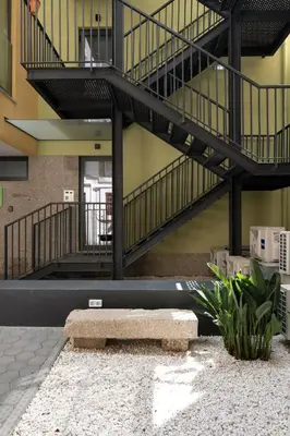 a bench in the middle of a building with a staircase at Cactus Apartment, by Bolhão Residences in Porto