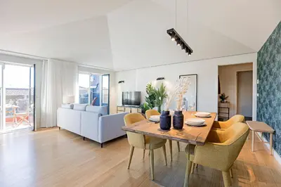 a dining room and living room with a table and chairs at Aliados Premium 1BR w/ Terrace by LovelyStay in Porto