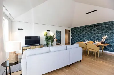 a living room with a white couch and a table at Aliados Premium 1BR w/ Terrace by LovelyStay in Porto