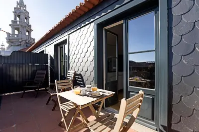 a patio with a table and chairs on a balcony at Aliados Premium 1BR w/ Terrace by LovelyStay in Porto