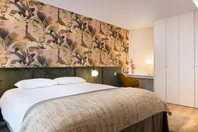 a bedroom with a large bed with a floral wallpaper at Savannah Apartment, by Bolhão Residences in Porto