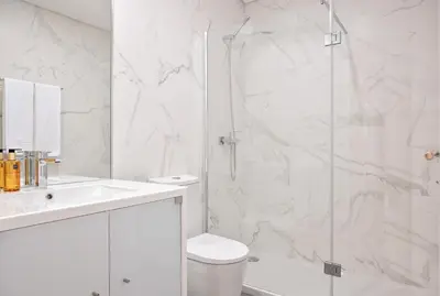 a white bathroom with a shower and a toilet at Savannah Apartment, by Bolhão Residences in Porto