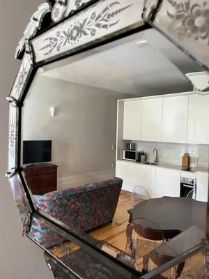 a mirror reflecting a kitchen with a couch and a table at CASA SANTO ILDEFONSO in Porto