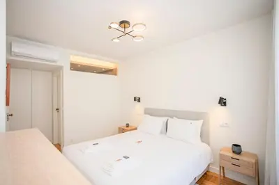 a bedroom with a white bed and a ceiling fan at Liiiving in Porto - Design Bright House in Porto