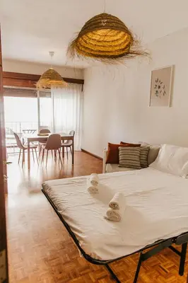 a bedroom with a bed and a dining room at Apartamento Santos Pousada in Porto
