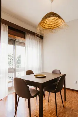 a dining room table with chairs and a chandelier at Apartamento Santos Pousada in Porto