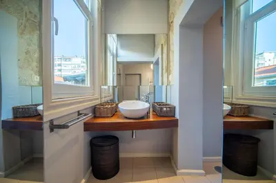 a bathroom with two sinks and two windows at Near Boavista - Free Parking in Porto