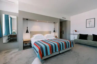 a white bedroom with a bed and a couch at The Editory Artist Baixa Porto Hotel in Porto