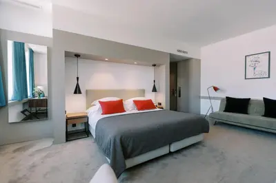 a bedroom with a large bed with two red pillows at The Editory Artist Baixa Porto Hotel in Porto
