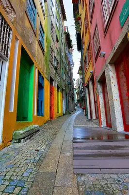 an empty street with colorful buildings and a bench at Stay In Apartments in Porto