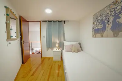 a bedroom with a large white bed in a room at OPORTO GUEST Oliveira House in Porto