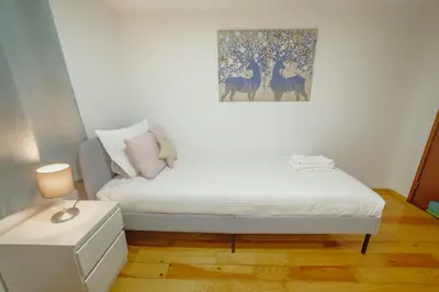 a small bedroom with a bed and a painting on the wall at OPORTO GUEST Oliveira House in Porto