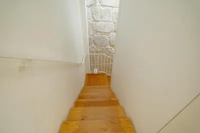a hallway with white walls and a wooden floor at OPORTO GUEST Bonfim Apartment in Porto