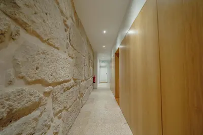a room with a stone wall and a hallway at OPORTO GUEST Bonfim Apartment in Porto