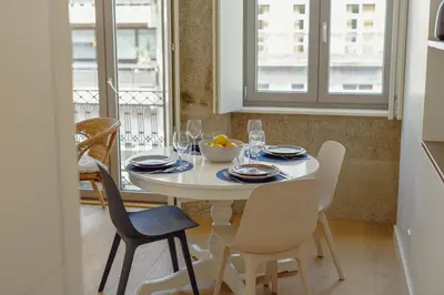 a white dining room table with chairs and a bowl of fruit on it at OPORTO GUEST Bonfim Apartment in Porto