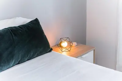 a bed with a green pillow and a candle on a table at GuestReady - Shades of Blue with Balcony in Porto