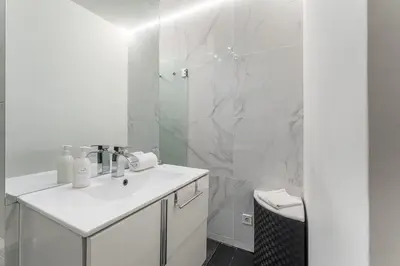 a white bathroom with a sink and a shower at GuestReady - Shades of Blue with Balcony in Porto