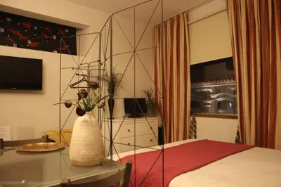 a bedroom with a bed and a vase with flowers on a table at Apartment Art Jazz Music in Porto
