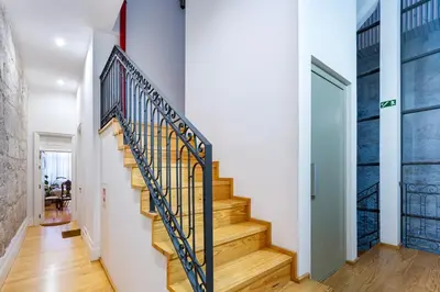 a staircase in a home with white walls and wood floors at Majestic Cafe - Porto City Center Modern Apartment in Porto