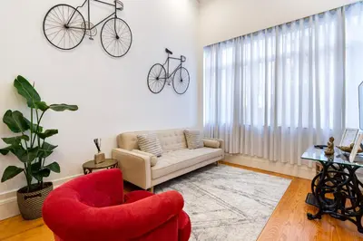 a living room with a couch and two bikes on the wall at Majestic Cafe - Porto City Center Modern Apartment in Porto