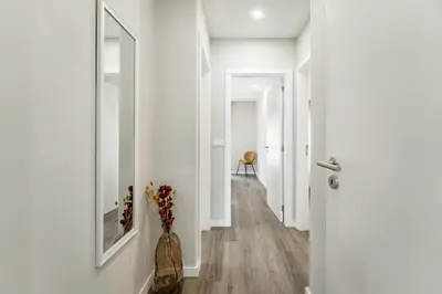 a hallway with white walls and a vase of flowers at Nomad's Family - 2BED Casa da Música in Porto