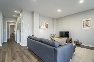 a living room with a blue couch and a tv at Nomad's Family - 2BED Casa da Música in Porto