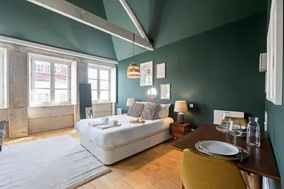 a bedroom with green walls and a bed and a table at Lóios 66 by LovelyStay in Porto