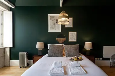 a bedroom with a large bed with a green wall at Lóios 66 by LovelyStay in Porto