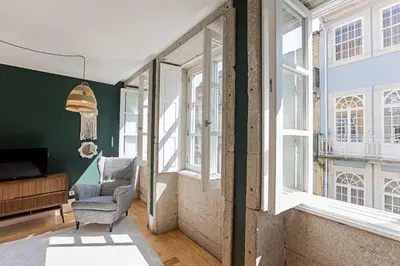 a living room with a chair and windows at Lóios 66 by LovelyStay in Porto