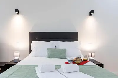 a bedroom with a bed with two glasses of wine at 150 Rivoli Apartments by LovelyStay in Porto