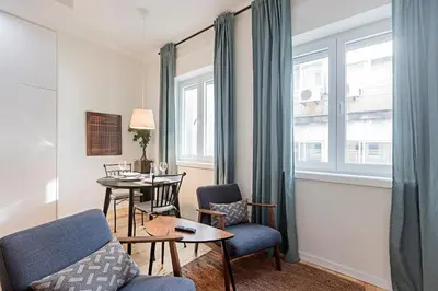 a living room with a couch and a table and a window at 150 Rivoli Apartments by LovelyStay in Porto