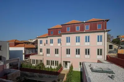 a large pink building with a red roof at 4CITY FLAT CAMARÃO in Porto