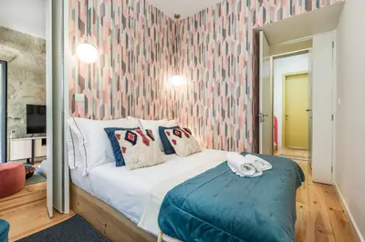 a bedroom with a bed with a pink wall at OPO Bonjardim 902 II in Porto