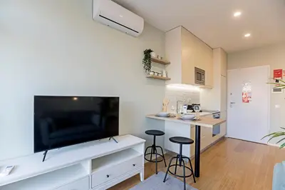 a living room with a large flat screen tv and a table at 31 Janeiro 157 - Charming 1BR Flat w/ AC & Balcony by LovelyStay in Porto