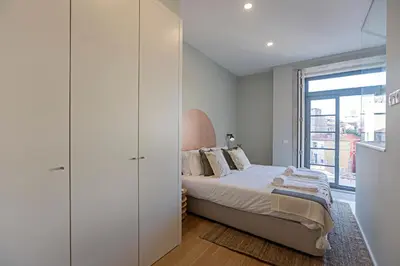 a bedroom with a bed and a large window at 31 Janeiro 157 - Charming 1BR Flat w/ AC & Balcony by LovelyStay in Porto