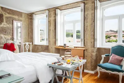 a bedroom with a bed and a table and chairs at 1872 River House by Olivia in Porto