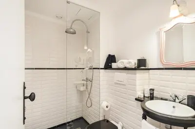 a white bathroom with a sink and a shower at 1872 River House by Olivia in Porto